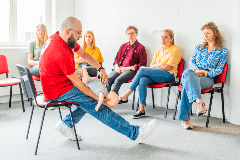 Un formateur démontrant les gestes de premiers secours pour un bébé