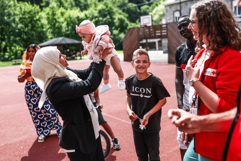 Moment de jeu entre personnes demandeuses d'asile et volontaire, au centre Yvoir