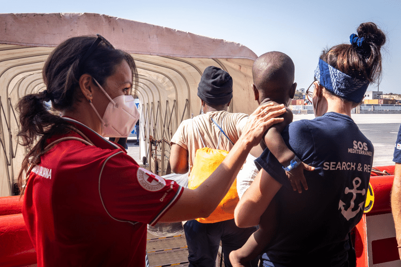 Une volontaire qui accueil des personnes migrantes